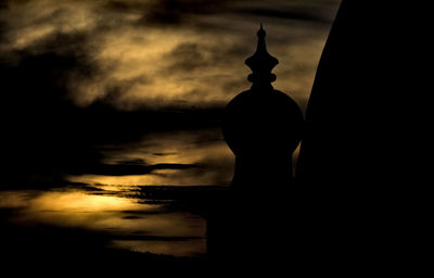 Silhouette landscape against cloudy sky