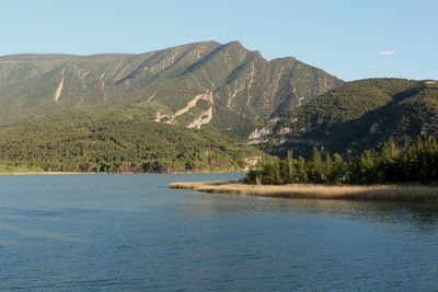 Scenic view of lake by mountains against sky