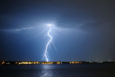 Lightning over lake at night