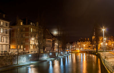 Canal passing through city buildings at night