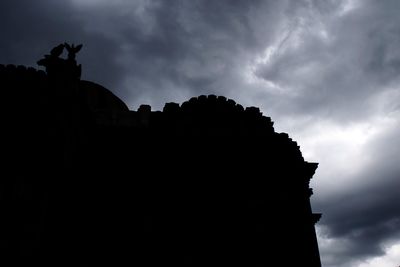 Low angle view of silhouette statue against sky