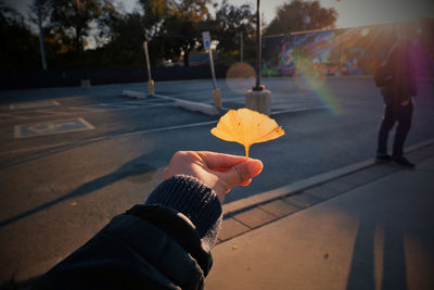 Close-up of person holding umbrella on street