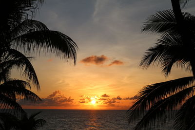Scenic view of sea against dramatic sky during sunset