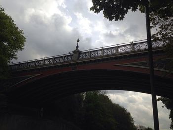 Low angle view of bridge against cloudy sky