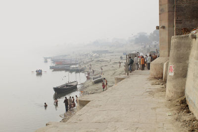 People at seaside against sky