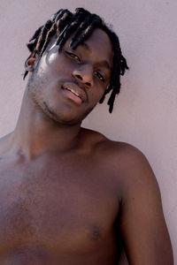 Young black man next to the pink wall portrait