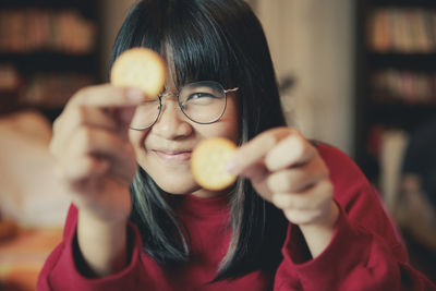 Portrait of young woman holding eyeglasses