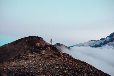 Person on rock against sky