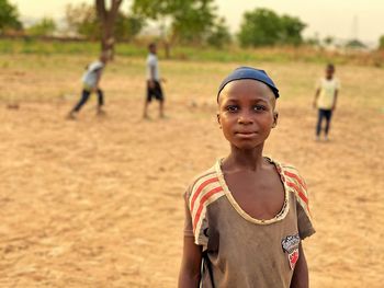 Portrait of smiling teenage boy standing on field