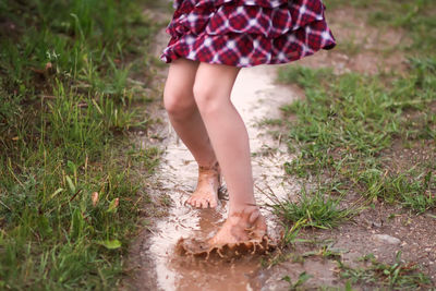 Low section of woman standing on field