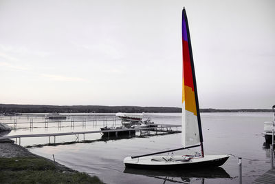 Sailboat moored on sea against sky