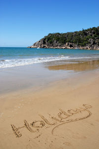 Scenic view of beach against clear blue sky