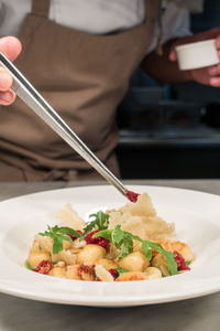 Midsection of chef styling food at table