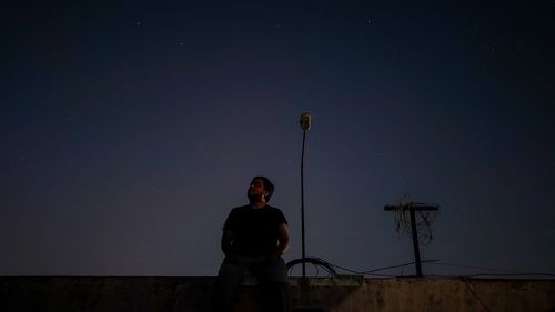 Man standing against sky at night