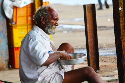 Man eating food while sitting outdoors