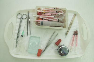 High angle view of medical supplies in tray on gray background