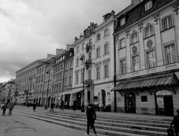 People walking on road against buildings