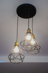 Low angle view of illuminated pendant light hanging from ceiling