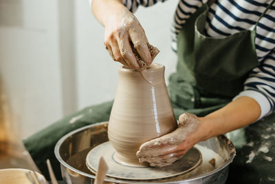 Midsection of potter making earthenware at workshop