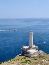 Lighthouse by sea against sky