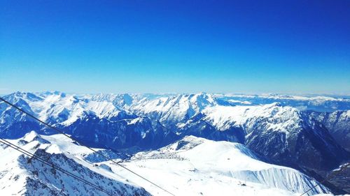 Scenic view of snowcapped mountains against clear blue sky