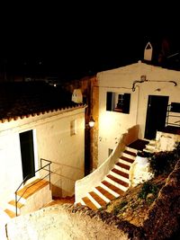 Old building by street against sky at night