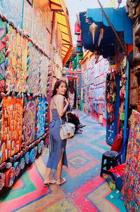 Full length portrait of girl holding multi colored market