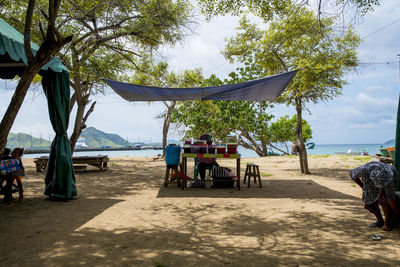 Rear view of people at beach against sky