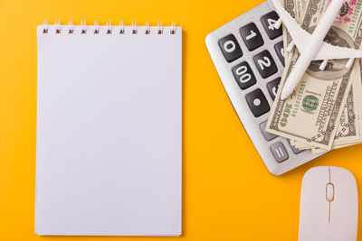 High angle view of yellow paper over white background