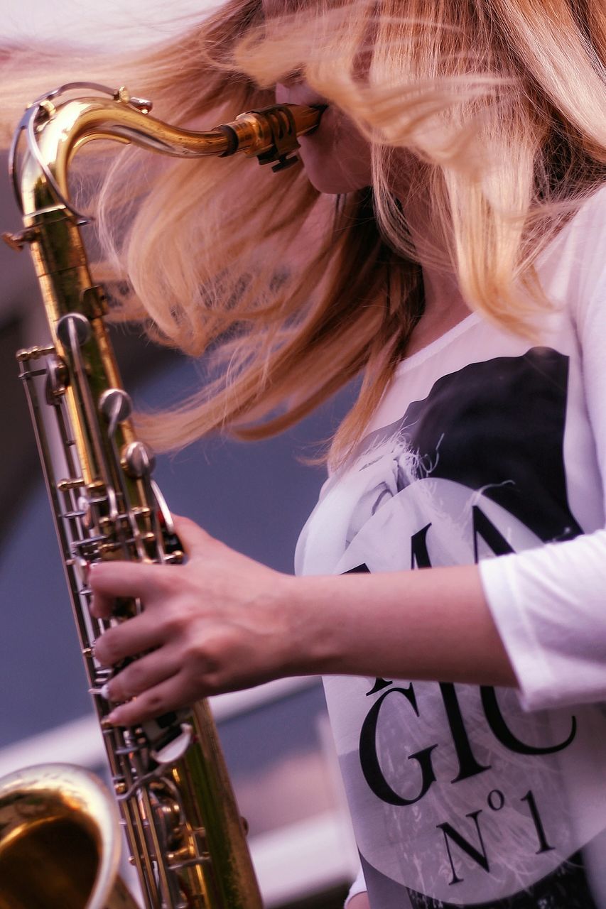 music, musical instrument, arts culture and entertainment, real people, one person, playing, saxophone, musician, leisure activity, lifestyles, performance, artist, blond hair, hair, wind instrument, skill, women, holding, musical equipment, hairstyle