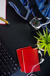 High angle view of computer keyboard with potted plant and personal accessories