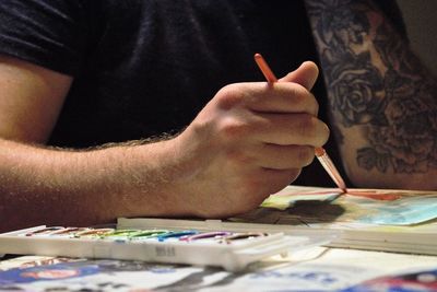 Midsection of man painting on paper