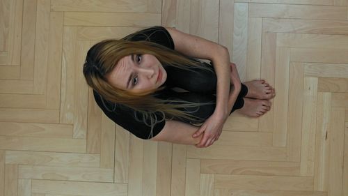 Portrait of a young woman lying on floor at home