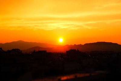 Silhouette buildings against sky during sunset