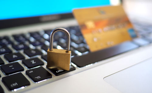 Close-up of padlock and credit card on keyboard