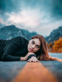 Portrait of young woman lying down outdoors