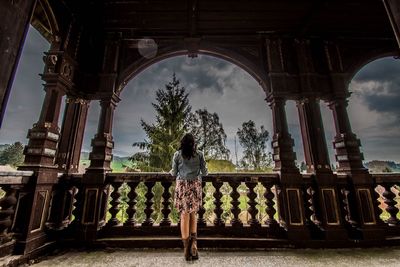 Rear view of woman standing at balcony