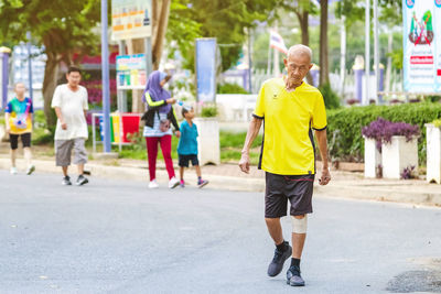 Rear view of people walking on street in city