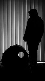 Silhouette man standing against curtain