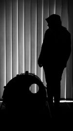 Silhouette man standing against curtain