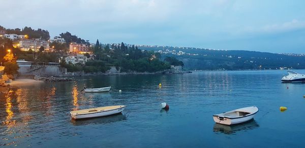 Boats moored in lake against sky