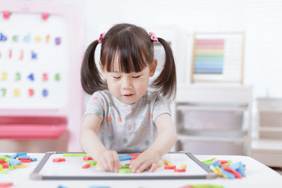 Young girl playing creative toy blocks for home schooling