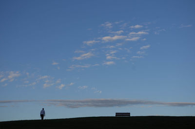 Silhouette man standing on field against sky