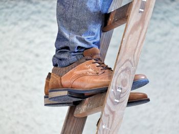 Low section of man standing on ladder