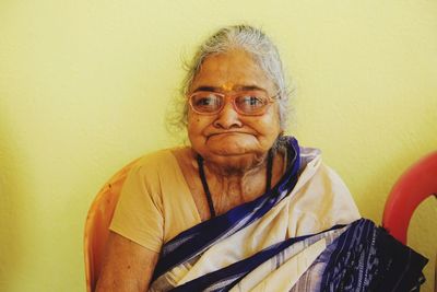 Portrait of smiling woman against wall