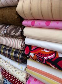 Close-up of stacked fabrics for sale in store