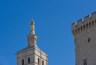 Low angle view of statue of building against blue sky