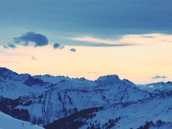 Scenic view of snowcapped mountains against sky during sunset