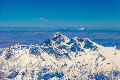 Scenic view of snowcapped mountains against blue sky