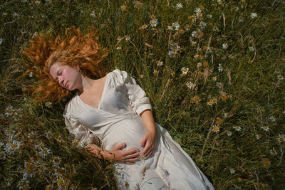 Young woman lying on field